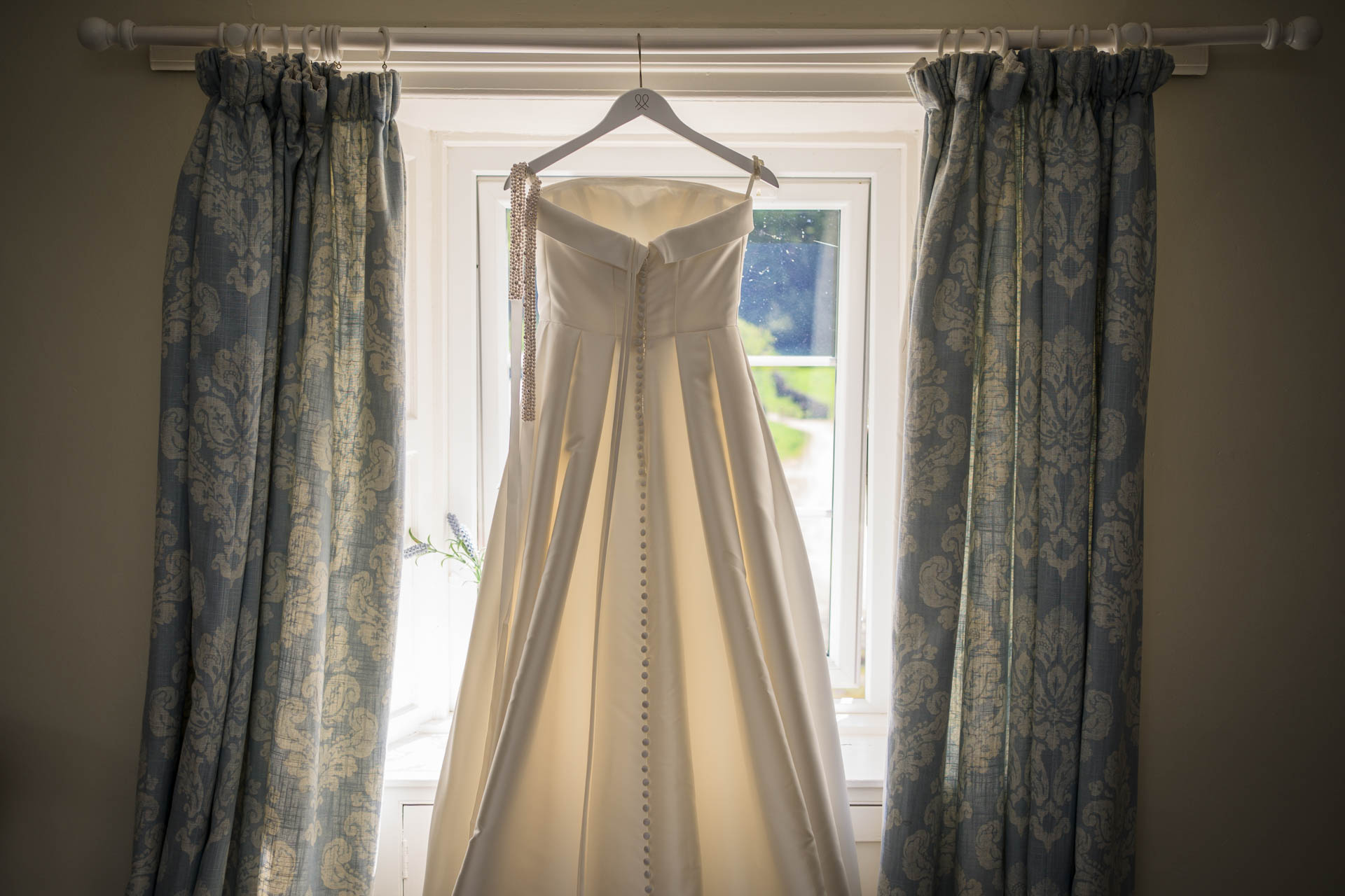 Wedding dress hanging in window