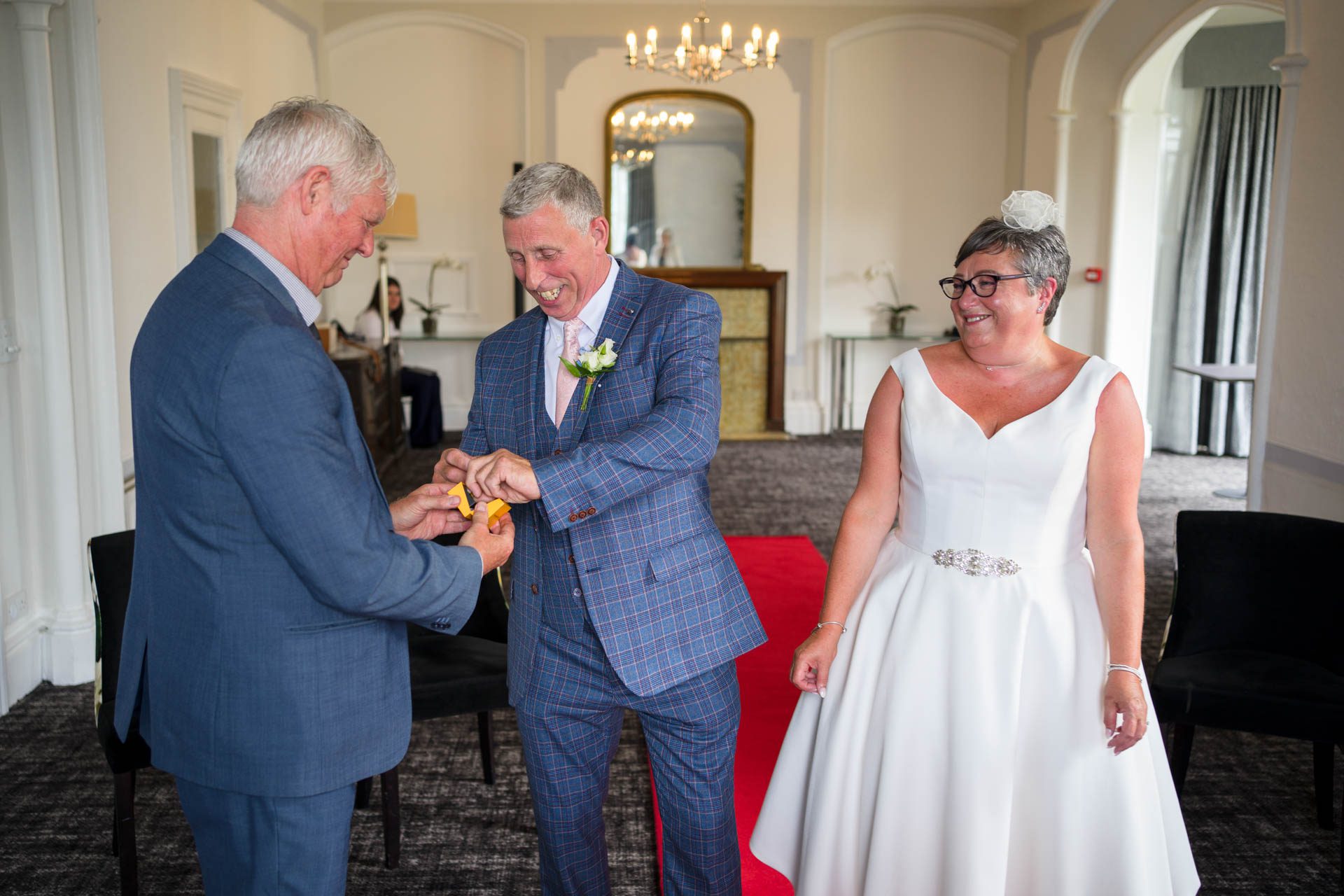 Groom taking wedding ring from best man during Low Wood Bay Resort Wedding ceremony