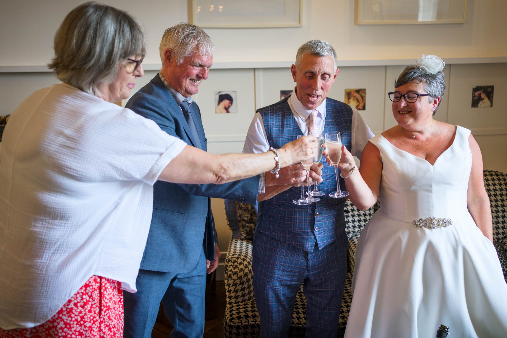 Bride, groom and guests clinking glasses of champagne