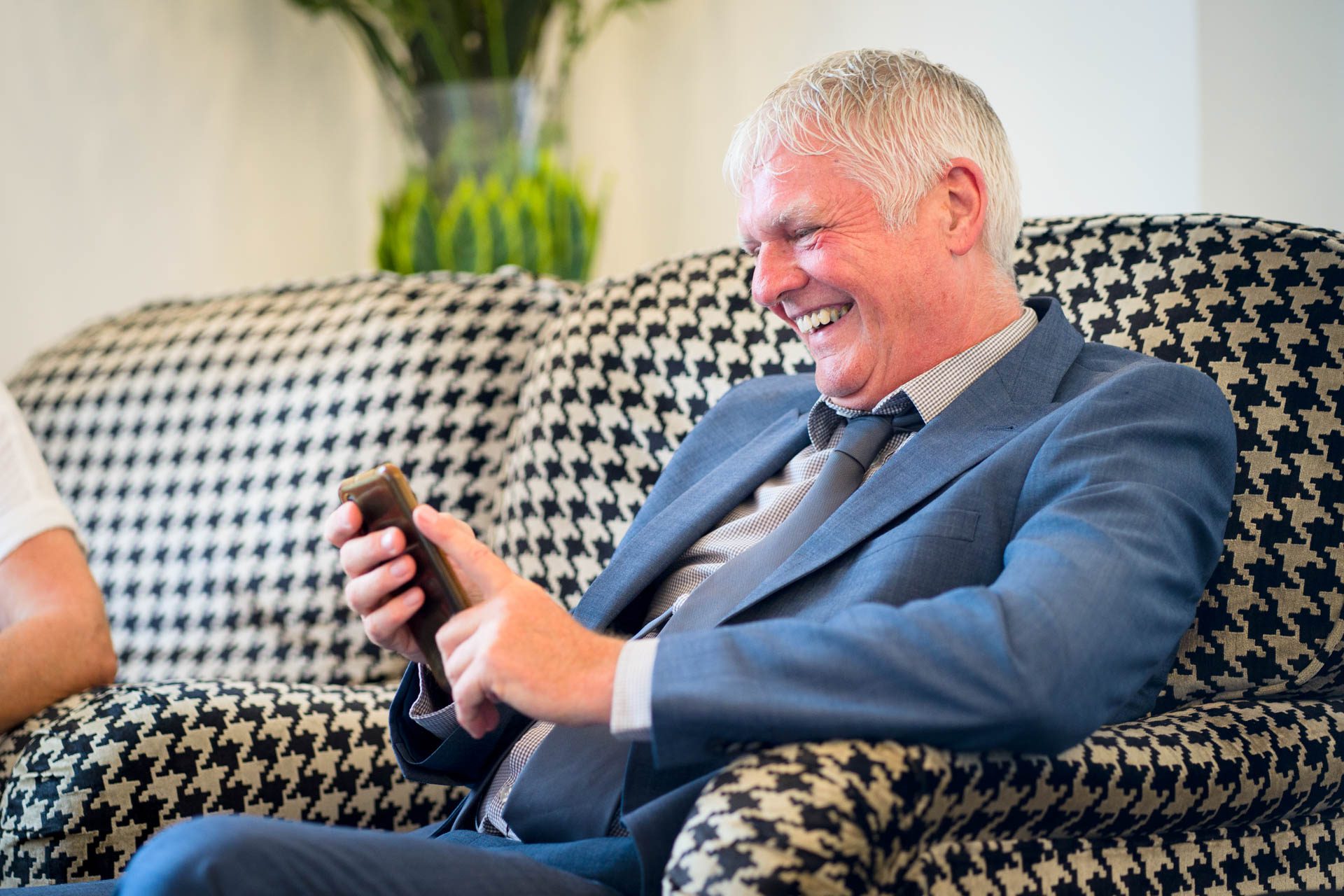 Best man laughing in bar of Low Wood Bay Resort and Spa