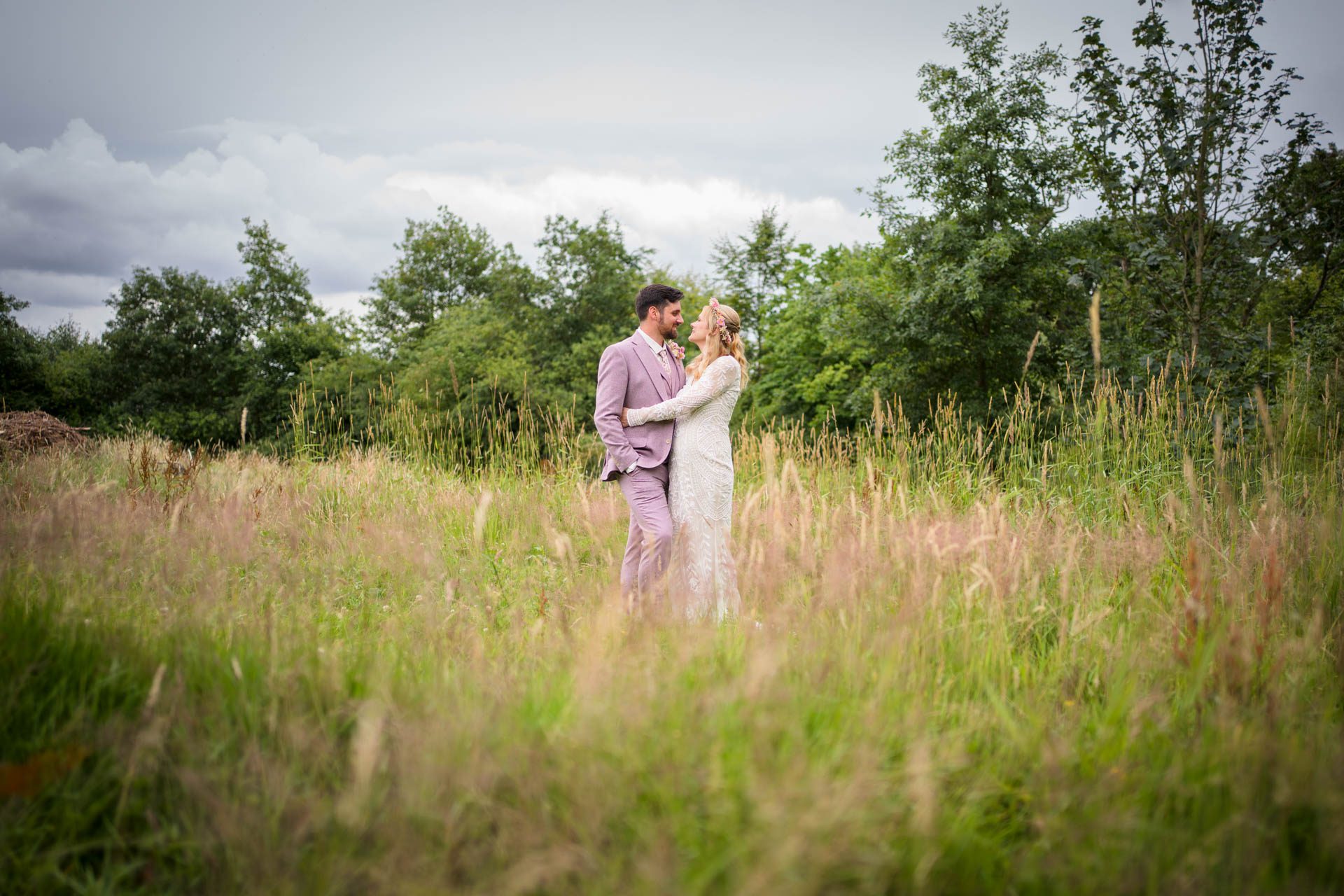 Wedding portrait at Ribble Valley wedding - bride and groom hugging in middle of field of long grass