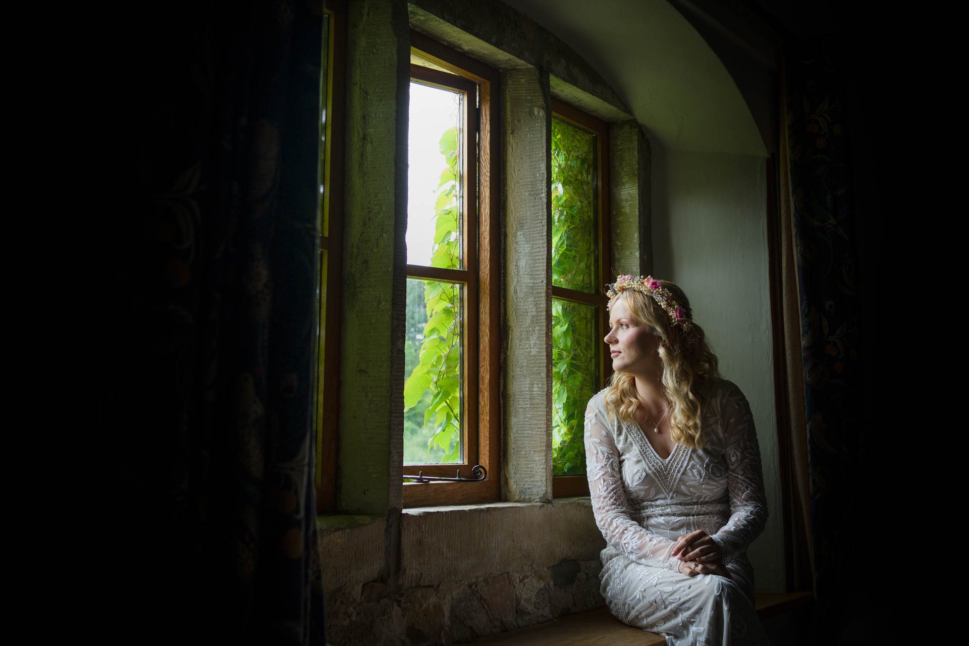 Chloe beautifully lit by natural window light, sitting and looking out of the window prior to her Ribble Valley Wedding